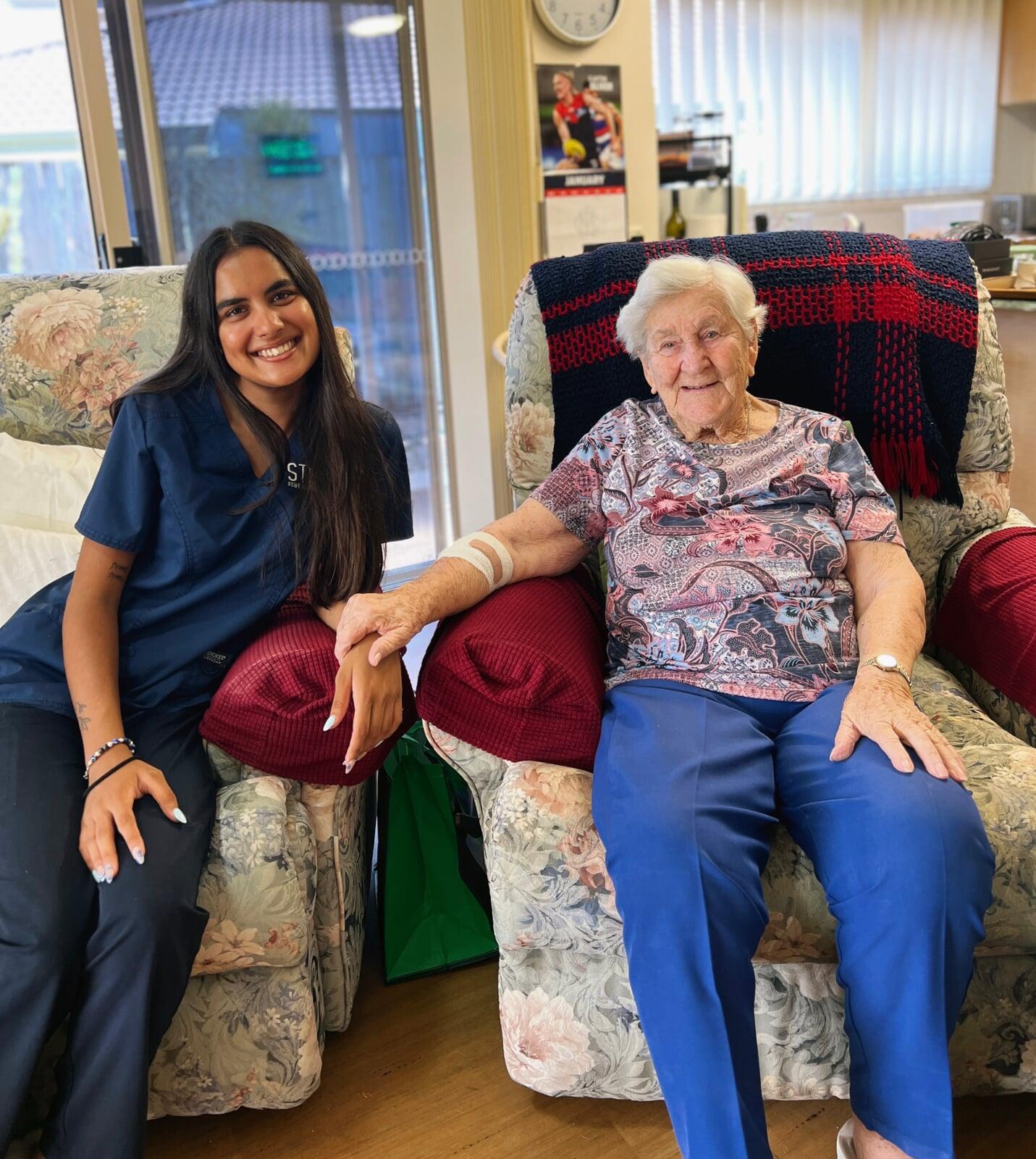 Image with Client sitting holding hands with Stable Home Care Staff